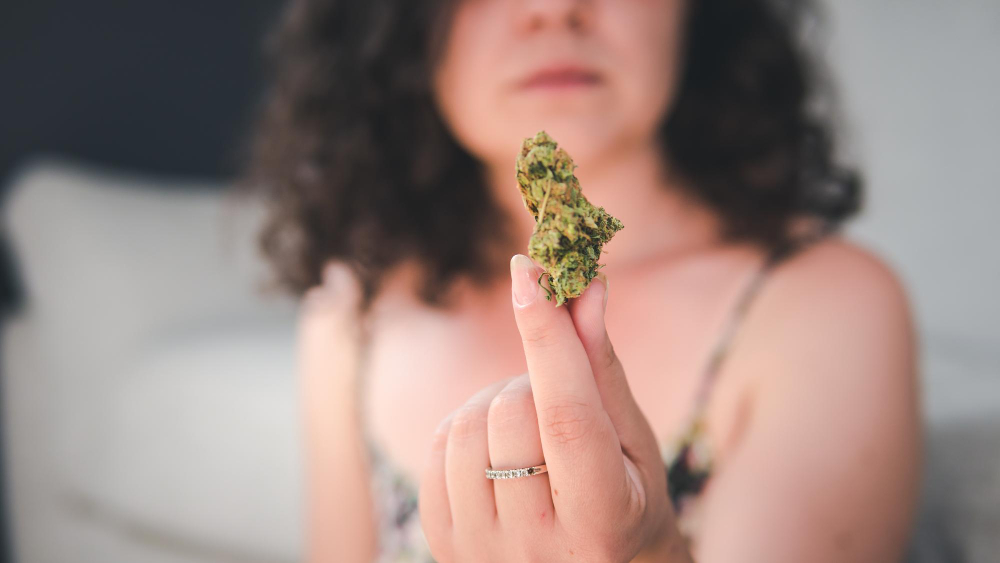 Woman thinking How to get a Medical Cannabis License in Michigan while looking at Cannabis.