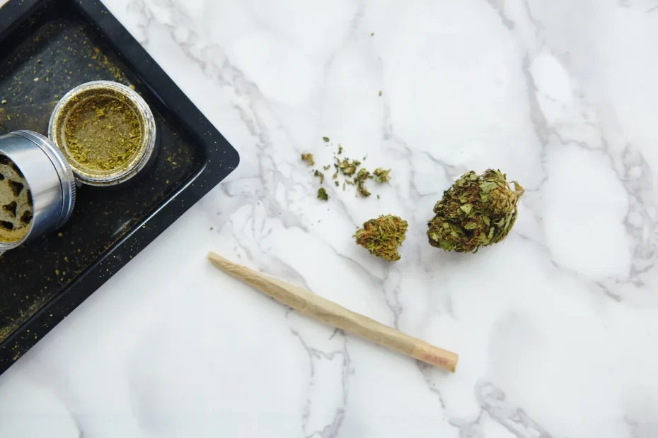 Ground cannabis, grinder, and pre-roll displayed on marble, demonstrating the preparation steps following techniques on how to dry cannabis properly.