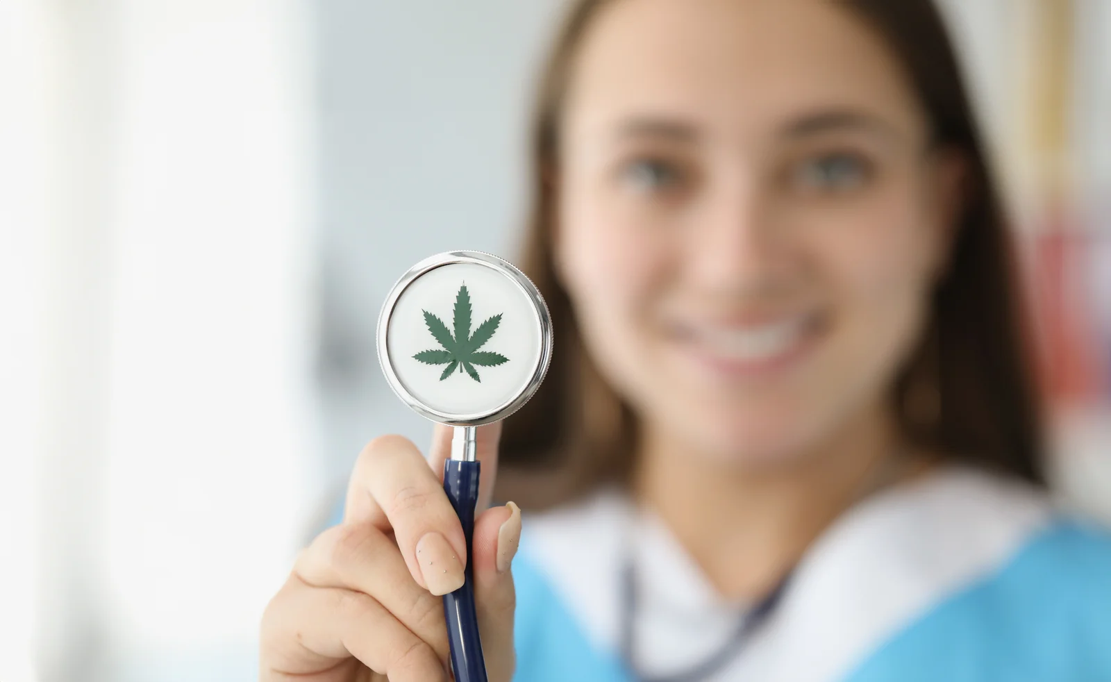 A smiling doctor holding a stethoscope featuring a marijuana leaf, symbolizing medical evaluations required for a cannabis license Florida.
